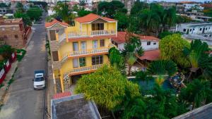 una casa gialla sul lato di una strada di Residence Tropical Garden a Boca Chica