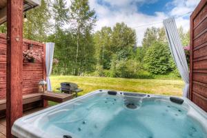 a hot tub on a patio with a view of a yard at Moon River Suites #3 in North Bend
