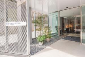 an entrance to a building with glass doors and potted plants at Hotel Oriental Express Tokyo Kamata in Tokyo