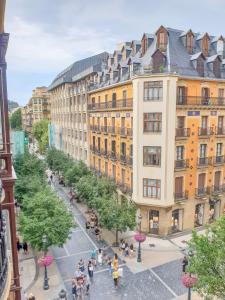 eine Gruppe von Menschen, die auf einer Straße vor Gebäuden spazieren in der Unterkunft Casa Centro in San Sebastián