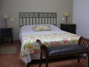 Cette chambre comprend un lit avec une couverture et une chaise. dans l'établissement Apartamento Rural Albus Albi, à Colmenar del Arroyo