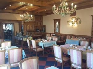 une salle à manger avec des tables et des chaises ainsi qu'un lustre dans l'établissement Hotel Dorfschenke, à Pirmasens