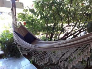 een hangmat hangend aan een boom in een tuin bij Pousada Suzimar in Fernando de Noronha