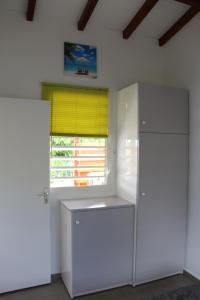 a kitchen with a white refrigerator and a window at L'Alizée in Sainte-Rose