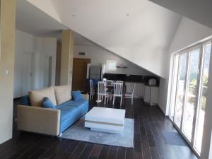 a living room with a blue couch and a table at Villa Aronija in Kotor