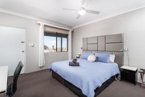 KurrajongArchibald Hotel的一间卧室，里面有一张大床，床上有一只泰迪熊