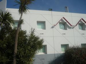 a white building with windows on the side of it at Lemon Hotel - Rouen in Le Mesnil-Esnard