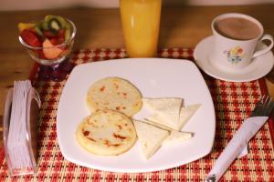 a plate of food with cheese and a cup of coffee at Hotel Sierra Nevada in Santa Marta
