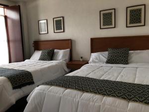 two beds in a hotel room next to each other at HOTEL CASA SILVESTRE in Zacatlán