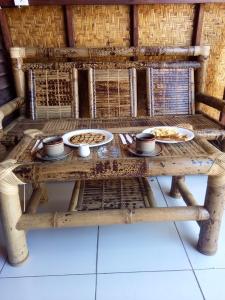 a wooden table with plates of food on it at Bale Hostel in Kuta Lombok