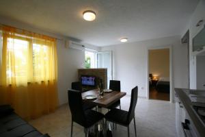 ein Wohnzimmer mit einem Tisch mit Stühlen und einer Couch in der Unterkunft Apartments Hodzic in Šilo