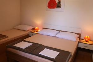 ein kleines Zimmer mit 2 Betten und 2 Lampen in der Unterkunft Apartments Hodzic in Šilo