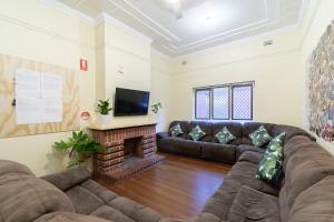 a living room with a couch and a fireplace at myOZexp Aberdeen Lodge in Perth