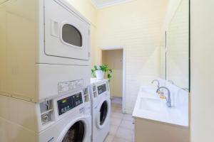 una lavanderia con lavatrice e lavandino di myOZexp Aberdeen Lodge a Perth Altre 15 foto