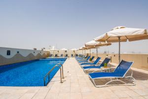 
a beach area with chairs, tables and umbrellas at Premier Inn Dubai Investments Park in Dubai
