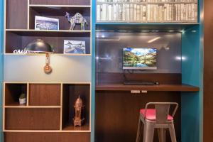 a room with a desk with a computer and a stool at Premier Inn Dubai Investments Park in Dubai +40 photos