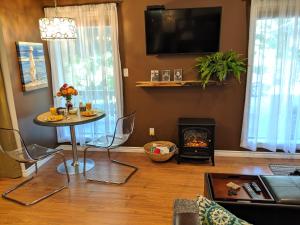 een woonkamer met een tafel en een open haard bij Oceanspray Hideaway in North Saanich