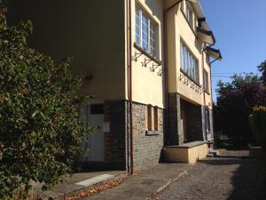 a brick building with a white door and windows at Studio Rue de Pommard in Francorchamps