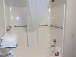a bathroom with a shower with a white shower curtain at MJ INN and SUITES in Marienville +16 photos