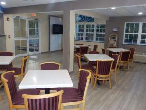 uma sala de jantar com mesas e cadeiras e uma televisão em SureStay Hotel by Best Western Marienville em Marienville