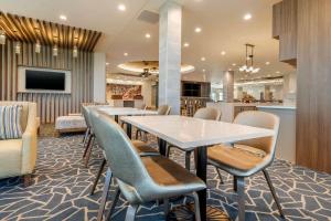 a restaurant with a table and chairs and a bar at Cambria Hotel Davenport Quad Cities in Bettendorf
