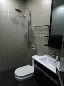 a bathroom with a shower and a toilet and a sink at NueVo Boutique Hotel, Kota Kemuning, Shah Alam in Shah Alam