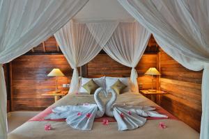 ペニダ島にあるMamaras Guest Houseのベッドルーム1室(ベッド1台に白鳥のタオル2枚付)