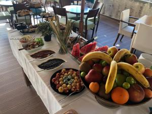 a long table with a bunch of fruit on it at Hotel Hugo in Altınoluk