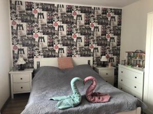 two swans are sitting on a bed in a bedroom at Villa Casa Mia in Balatonlelle
