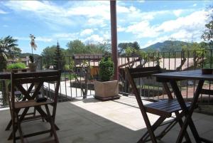 un patio con 2 mesas y sillas en un balcón en Carmelita en Sant Privat de Bas