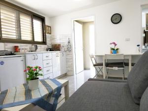 a kitchen with a couch and a table in a room at Carmela House in Arad
