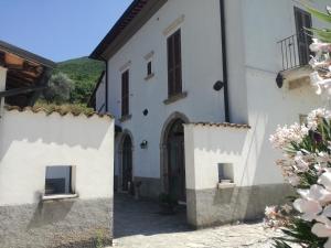 a white building with a gate and flowers at Agriturismo Sant'Erasmo in Paterno