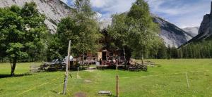 a log cabin in a field with mountains in the background at Haus Senn in Seefeld in Tirol