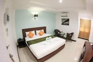 a bedroom with a bed and a desk and chairs at BK Place Hotel in Bung Kan