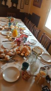 una mesa larga con platos y pasteles. en Agriturismo Ca' Isotta, en Castello di Serravalle