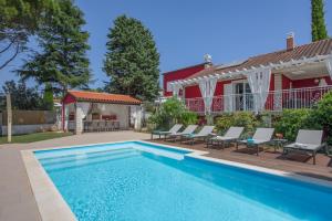 a swimming pool in front of a house at Astinian Villa Puntizela in Pula