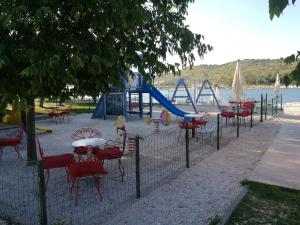a fence with tables and chairs and a playground at Villa Merica in Trogir