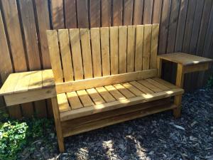 a wooden bench sitting next to a fence at Apartments Sharka in Děčín