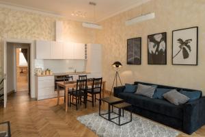 a living room with a couch and a table and a kitchen at M Terrace - Spacious City Center Apartment with Free Parking in Kaunas
