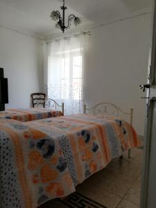 1 dormitorio con 2 camas y ventana en Le dimore del Mercante, en Luco neʼ Marsi