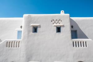 a white building with windows on the side of it at Amazing View Hotel Apartments in Agios Stefanos