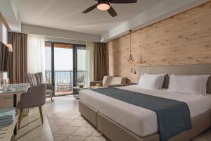 a hotel room with a large bed and a desk at Effect Algara Beach Resort - Ultra All Inclusive and Free Parking in Kranevo