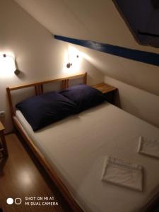 a bedroom with a large bed with a blue pillow at Apartment Kumbor in Herceg-Novi