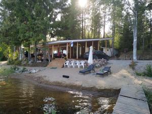 a house with a table and chairs next to a river at Tilhi 1 Cottage in Piojärvi