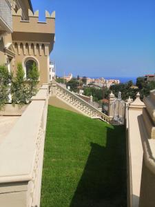 un balcón de una casa con césped verde en Sui Generis Tropea Luxury Rooms, en Tropea