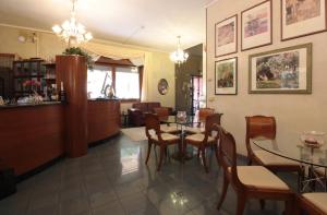 a restaurant with a table and chairs in a room at Hotel Rose&Crown in Correggio
