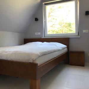 a bed in a room with a window at Apartament El Sol in Łukęcin