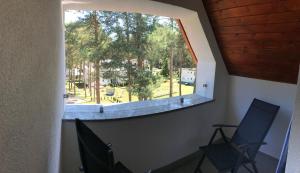 a window in a room with two chairs and a park at Apartament El Sol in Łukęcin