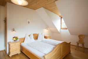 una camera con letto in legno e lenzuola bianche di Peterer Hof a Rasùn di Sotto