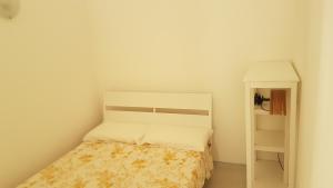 a small bedroom with a bed and a shelf at Chez Mémé in Lesina
